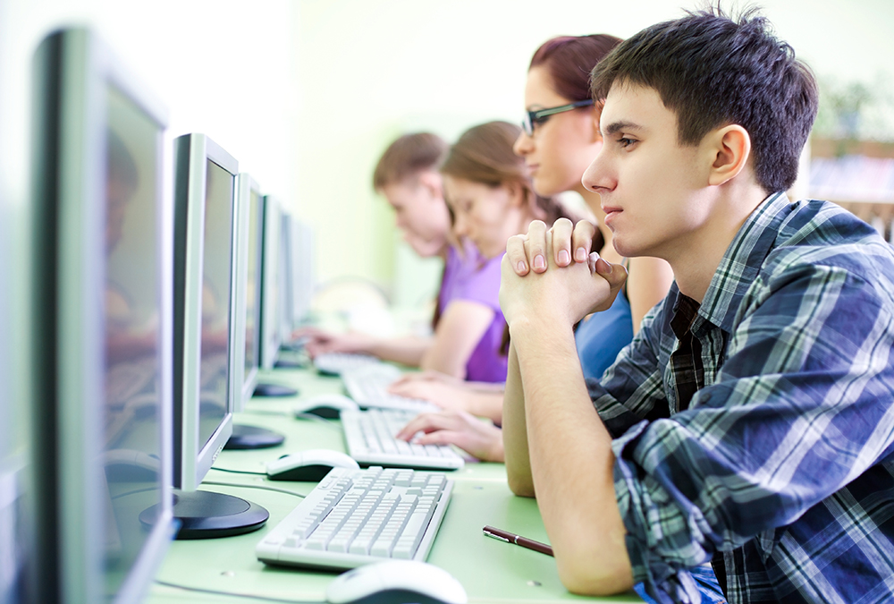 Young man learning on laptop with headphones