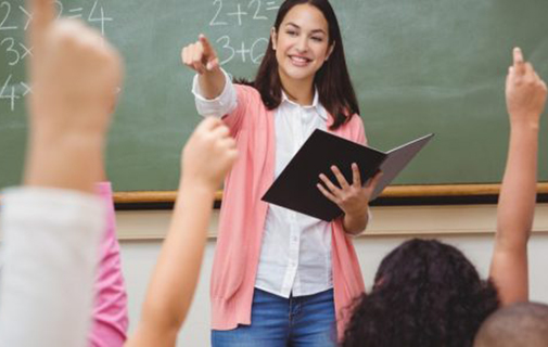 Math teacher in class with students raising hands